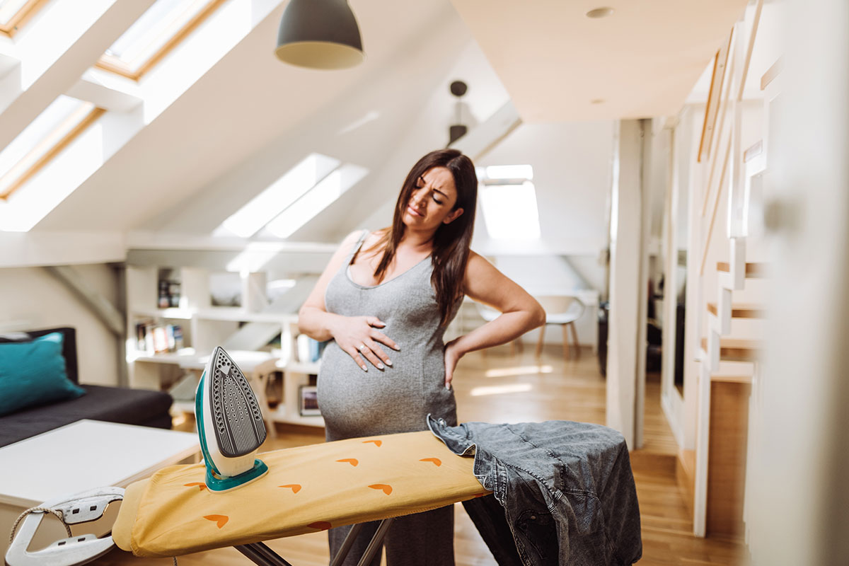 Femme enceinte qui fait du repassage