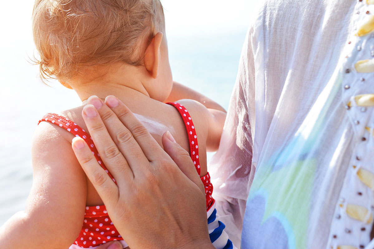 Application de crème solaire sur un bébé