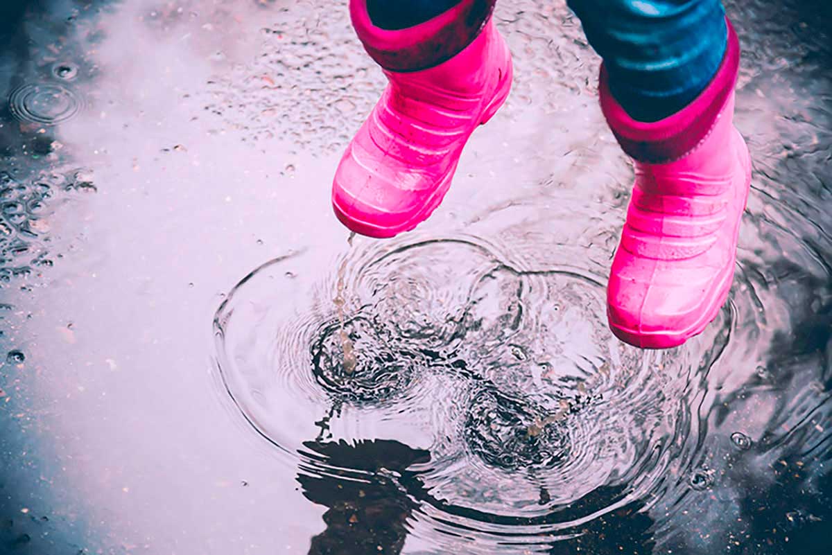 Bottes roses et flaque de pluie