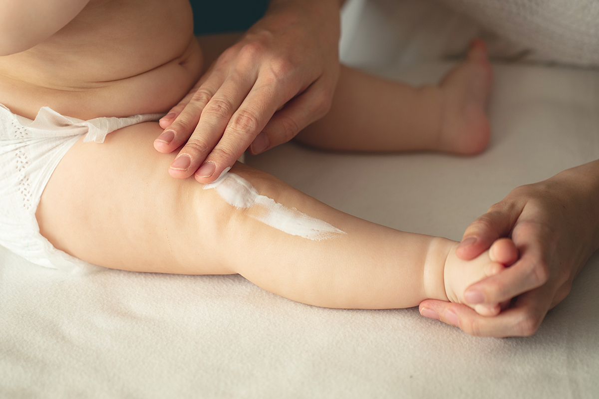 maman met de la crème solaire à son bébé