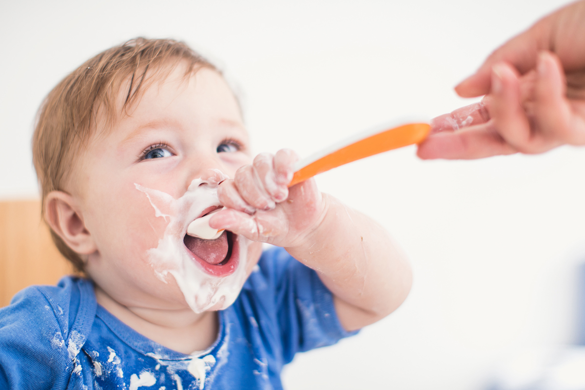 bébé apprend à manger tout seul avec une cuillère